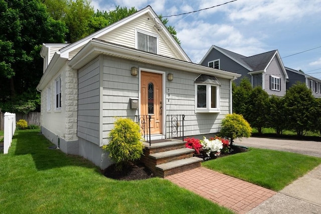 bungalow-style home featuring fence and a front yard