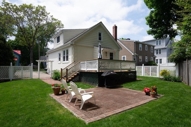 back of property with a yard, a fenced backyard, a patio, and a wooden deck