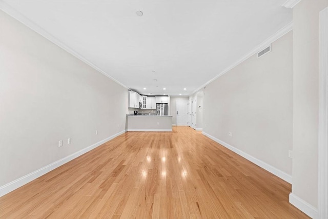 unfurnished living room with light wood finished floors, baseboards, visible vents, crown molding, and recessed lighting