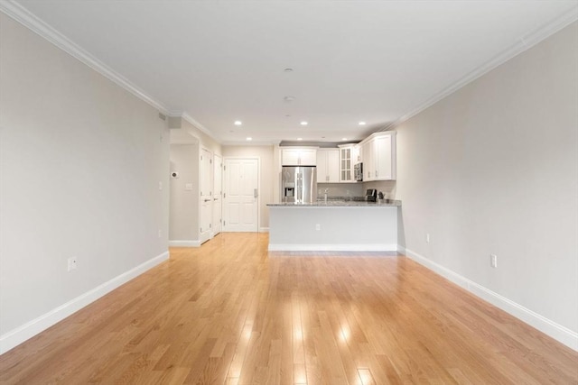 unfurnished living room with ornamental molding, light wood-type flooring, recessed lighting, and baseboards