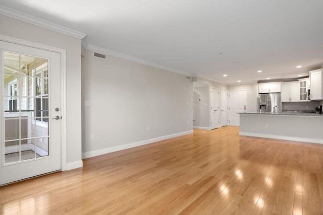 unfurnished living room featuring recessed lighting, visible vents, ornamental molding, light wood-type flooring, and baseboards