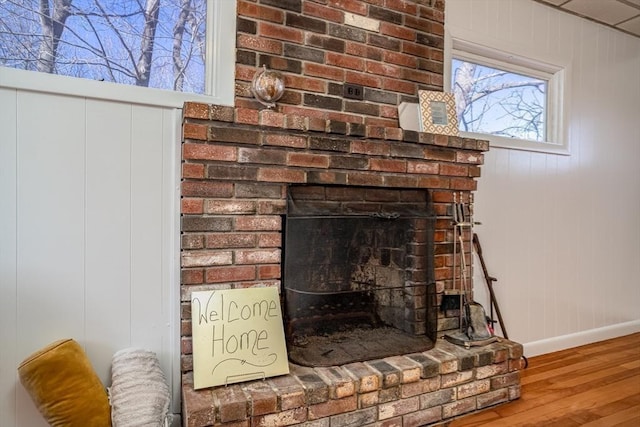 interior details featuring a fireplace, wood finished floors, and baseboards