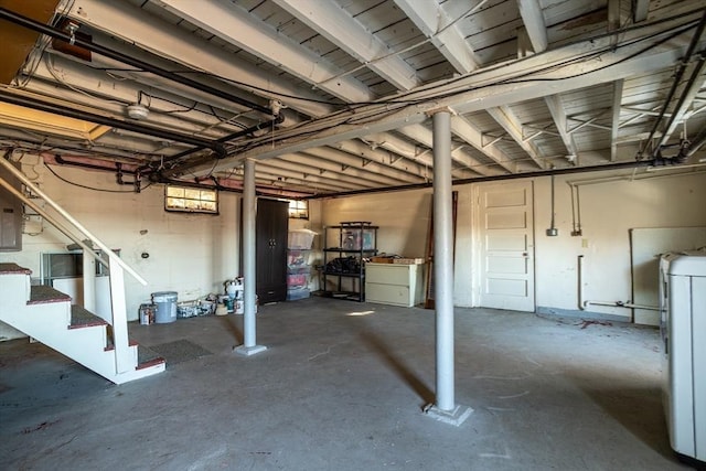 below grade area featuring stairway, washer / dryer, and electric panel