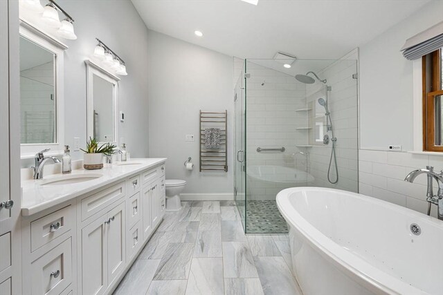 bathroom featuring a soaking tub, double vanity, a sink, and a stall shower