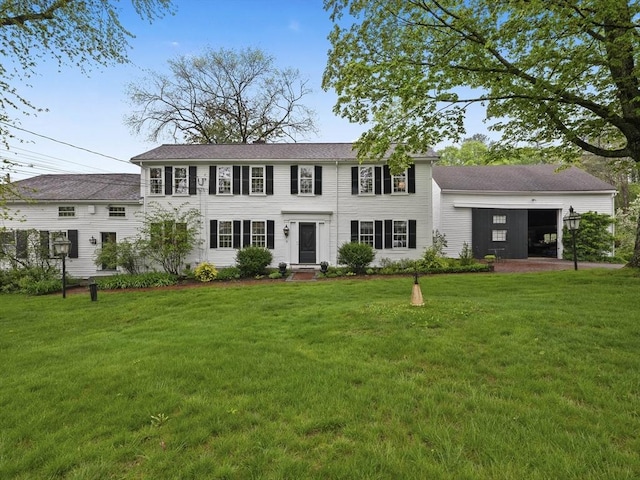 colonial house with a front yard and a garage