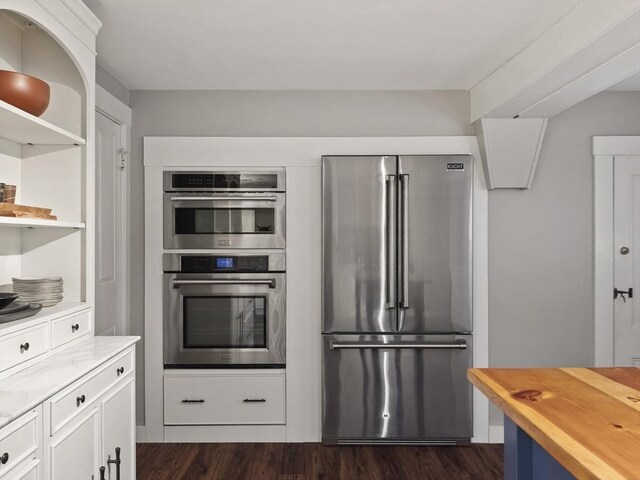 kitchen featuring stainless steel appliances, butcher block countertops, open shelves, dark wood-style flooring, and white cabinets