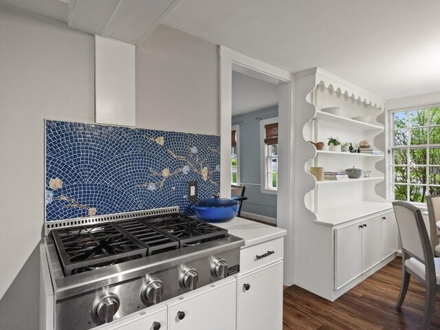 kitchen with stainless steel gas stovetop, dark wood-type flooring, decorative backsplash, light countertops, and white cabinetry