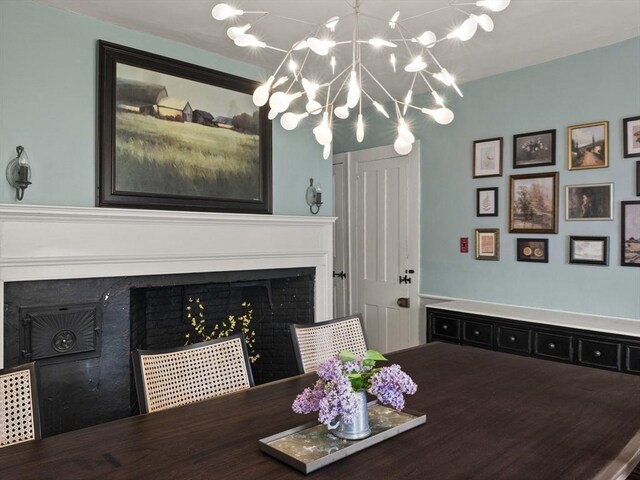 dining area featuring a chandelier and a fireplace