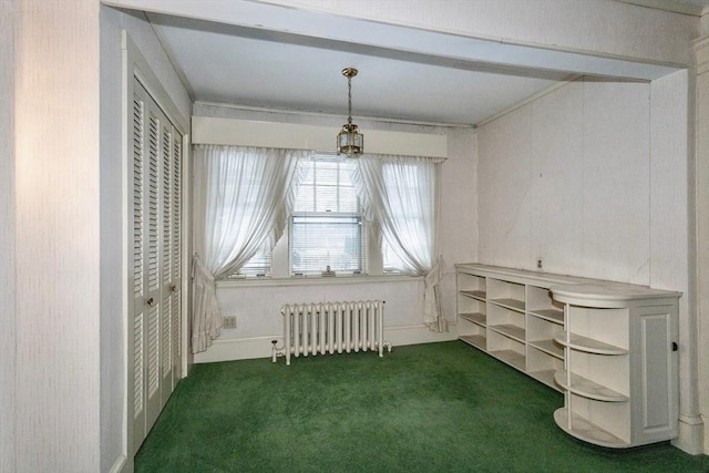 empty room featuring dark colored carpet and radiator