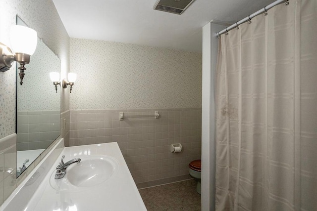 bathroom featuring tile walls, vanity, toilet, and a shower with shower curtain