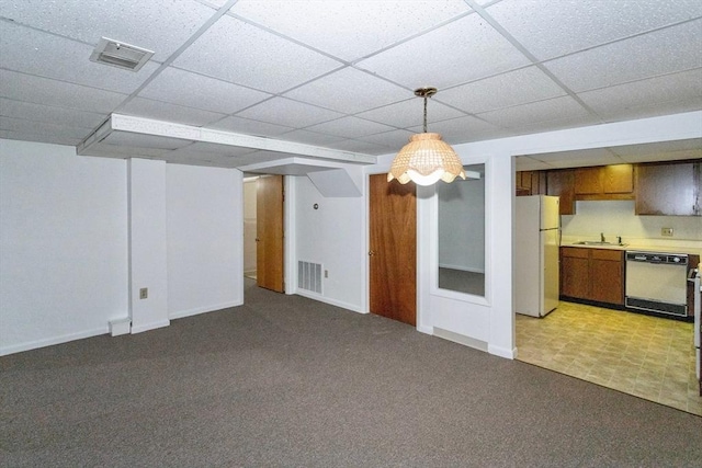 basement with light carpet, sink, a paneled ceiling, and white refrigerator