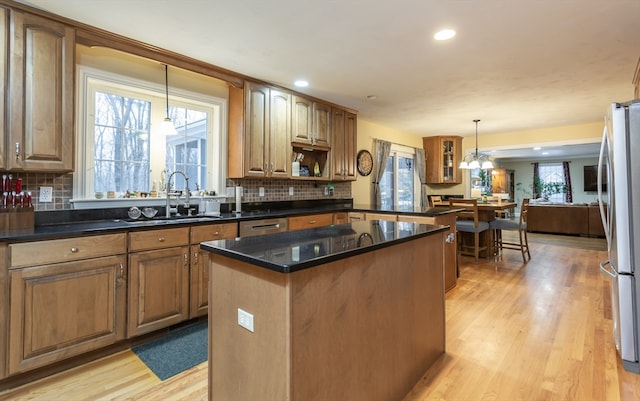 kitchen featuring a chandelier, backsplash, hanging light fixtures, and a kitchen island