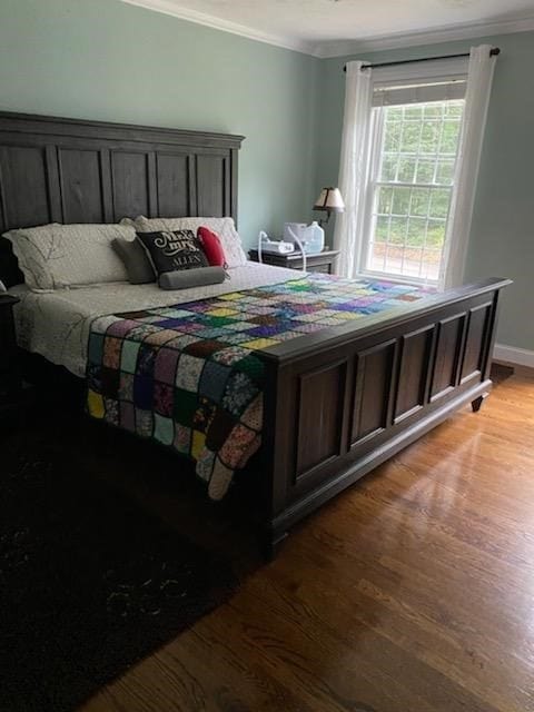 bedroom featuring ornamental molding and light hardwood / wood-style floors