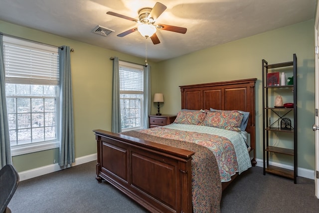 bedroom featuring dark carpet, multiple windows, and ceiling fan