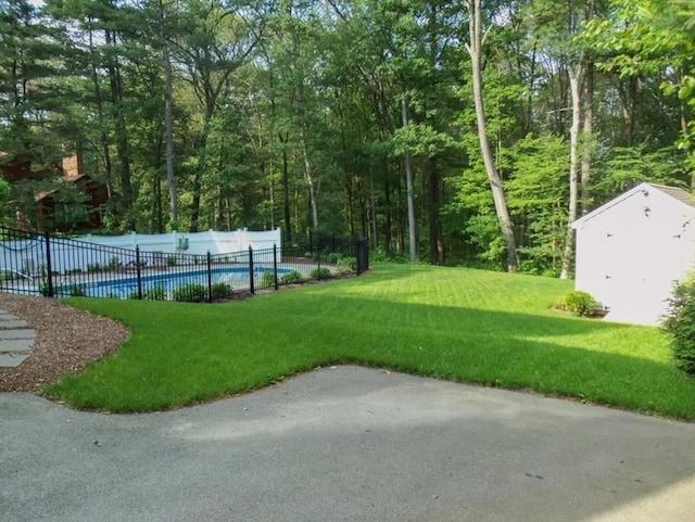 view of nearby features featuring a pool, a yard, and an outdoor structure