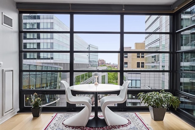 580 Washington St Unit 10A, Boston, MA 02111 - dining space with wood finished floors, a wall of windows, and a city view