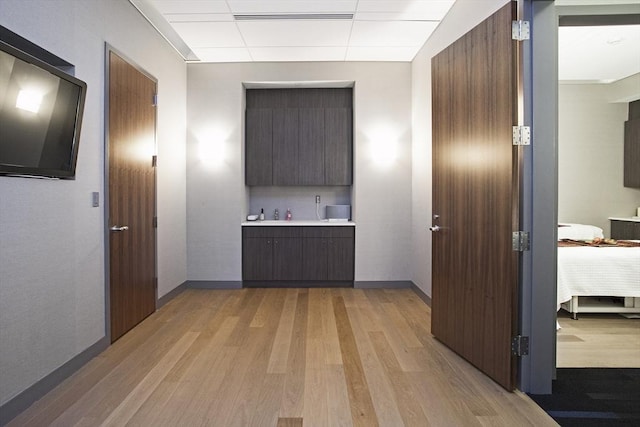 580 Washington St Unit 10A, Boston, MA 02111 - hall featuring light wood-style flooring, a drop ceiling, and baseboards