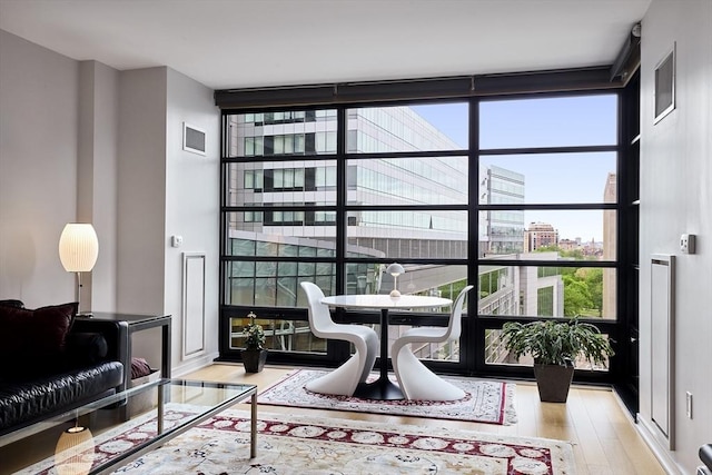 580 Washington St Unit 10A, Boston, MA 02111 - living room with wood finished floors, a wall of windows, plenty of natural light, and a city view