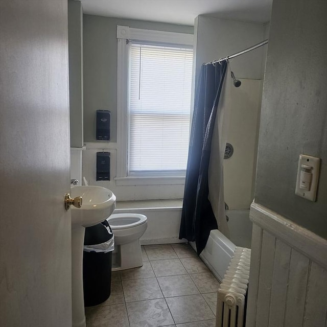 bathroom featuring radiator heating unit, plenty of natural light, tile patterned floors, and toilet