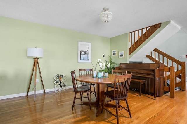 dining area with hardwood / wood-style floors and an inviting chandelier