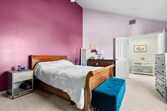 bedroom with light colored carpet and lofted ceiling