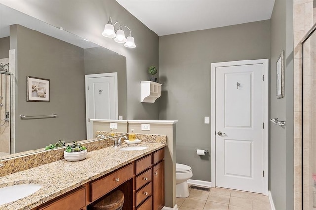 bathroom featuring tile patterned flooring, walk in shower, vanity, and toilet