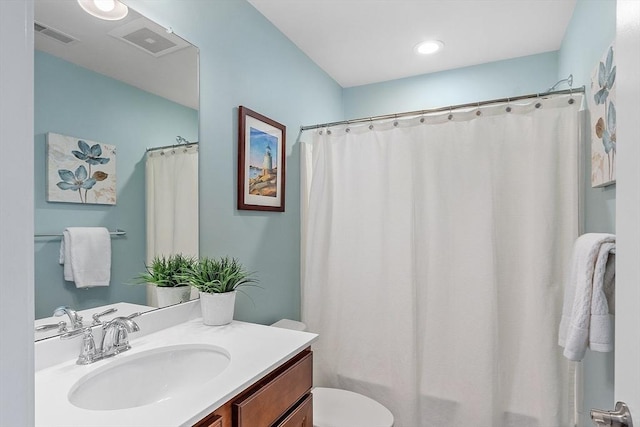 bathroom with vanity, toilet, and walk in shower