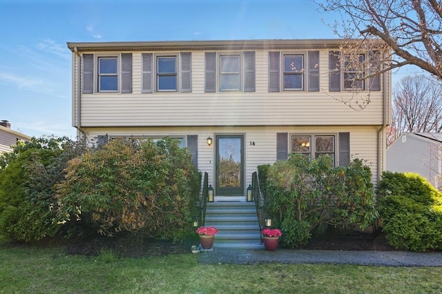 colonial inspired home featuring a front lawn and entry steps