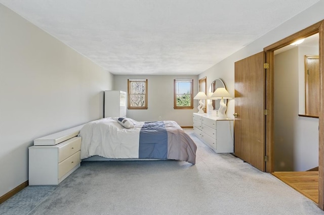 bedroom with baseboards and light colored carpet