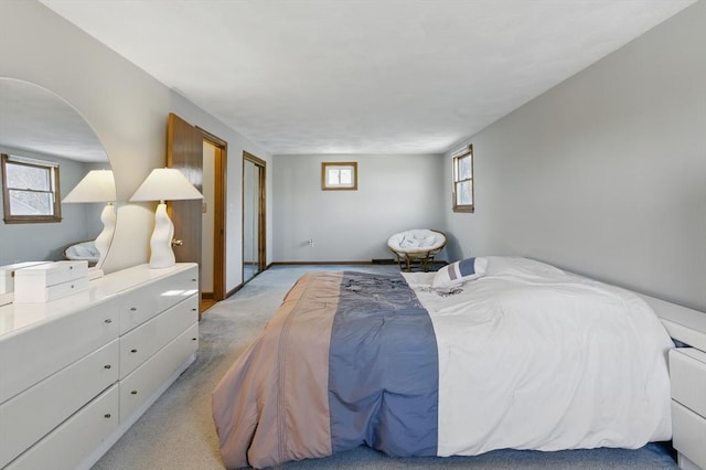 bedroom with baseboards and light colored carpet