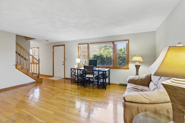 living area featuring wood finished floors, visible vents, stairs, and baseboards