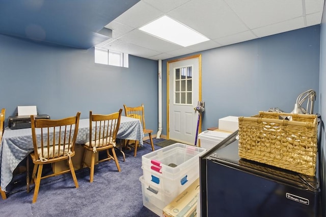 dining space featuring carpet flooring and a drop ceiling