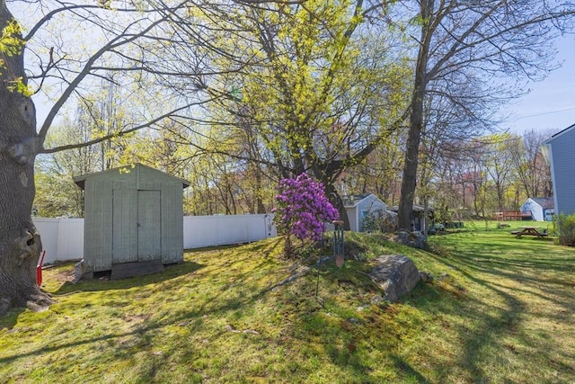 view of yard with an outdoor structure, a shed, and a fenced backyard