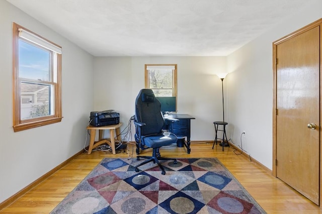 office space featuring baseboards and light wood-style floors
