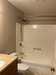 full bathroom with vanity, washtub / shower combination, and toilet