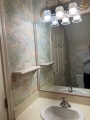 bathroom with vanity, a chandelier, and toilet