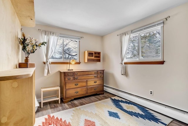 bedroom with multiple windows, baseboard heating, dark wood finished floors, and baseboards