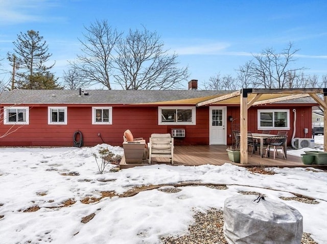 snow covered back of property featuring a wooden deck