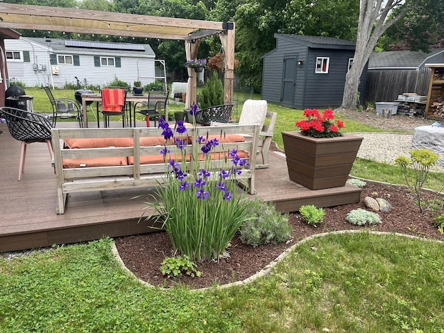 deck featuring outdoor dining space, a lawn, an outbuilding, and a storage shed