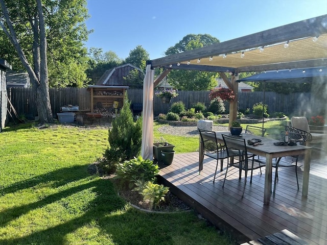 view of yard featuring outdoor dining area, a wooden deck, and a fenced backyard