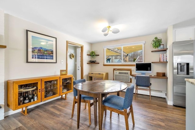 dining area featuring dark wood-style flooring, baseboard heating, and a wall mounted AC