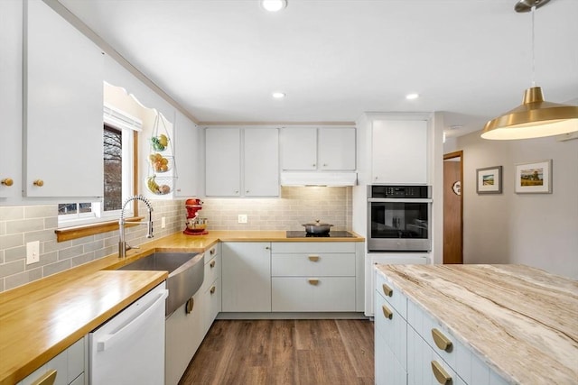 kitchen with tasteful backsplash, dark wood finished floors, oven, white dishwasher, and a sink