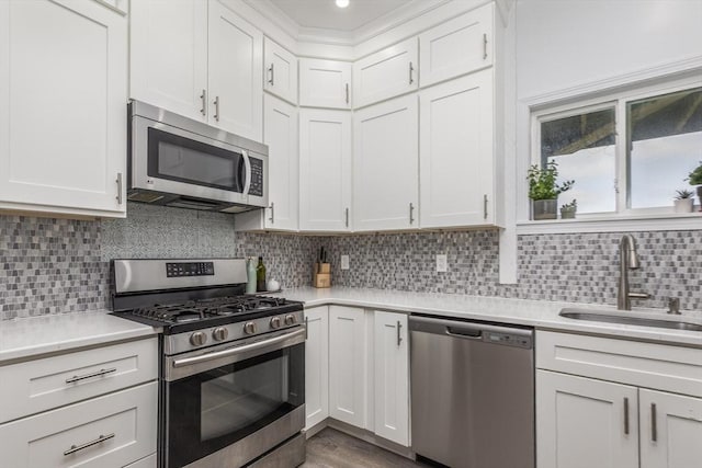65 Water St Unit 2, Danvers, MA 01923 - kitchen with appliances with stainless steel finishes, light countertops, white cabinetry, and tasteful backsplash