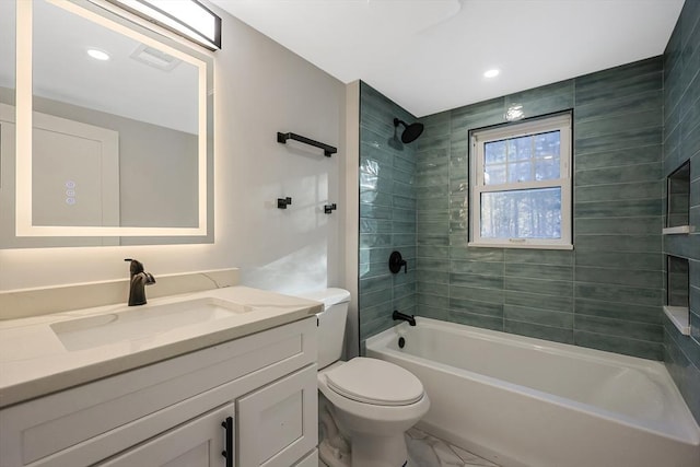 full bathroom featuring vanity, tiled shower / bath, and toilet