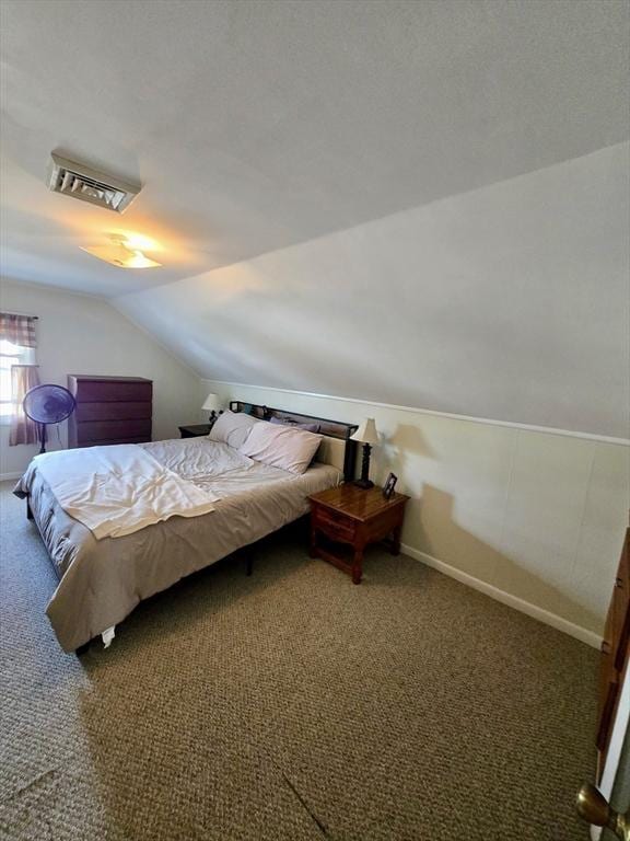 carpeted bedroom with lofted ceiling and baseboards