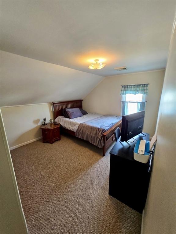 bedroom featuring lofted ceiling and carpet floors
