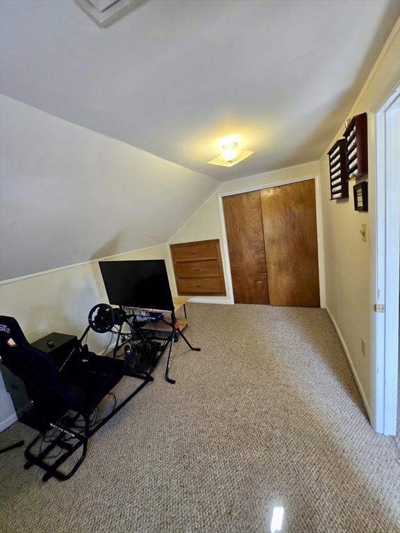 bonus room featuring lofted ceiling, carpet floors, a desk, and baseboards