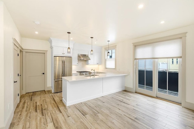 2-6 Market St Unit 2, Newburyport, MA 01950 - kitchen featuring under cabinet range hood, stainless steel fridge, light wood finished floors, a peninsula, and light countertops