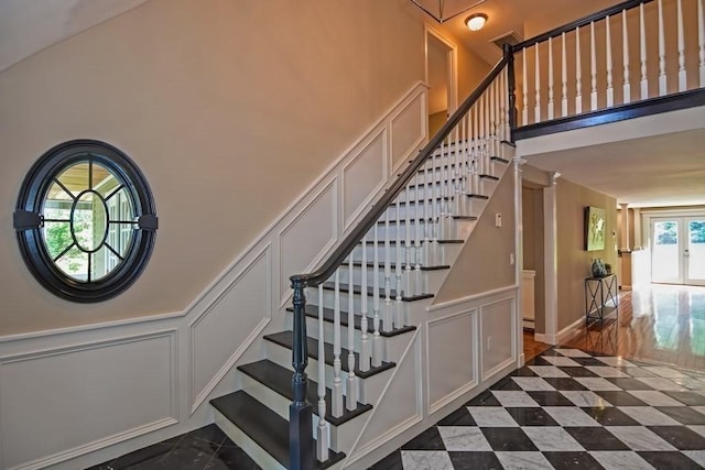 stairs featuring a decorative wall and a high ceiling