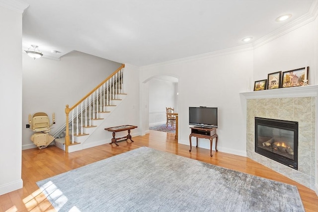 38 Tarbell St Unit 1B, Pepperell, MA 01463 - living room featuring arched walkways, wood finished floors, ornamental molding, stairs, and a fireplace